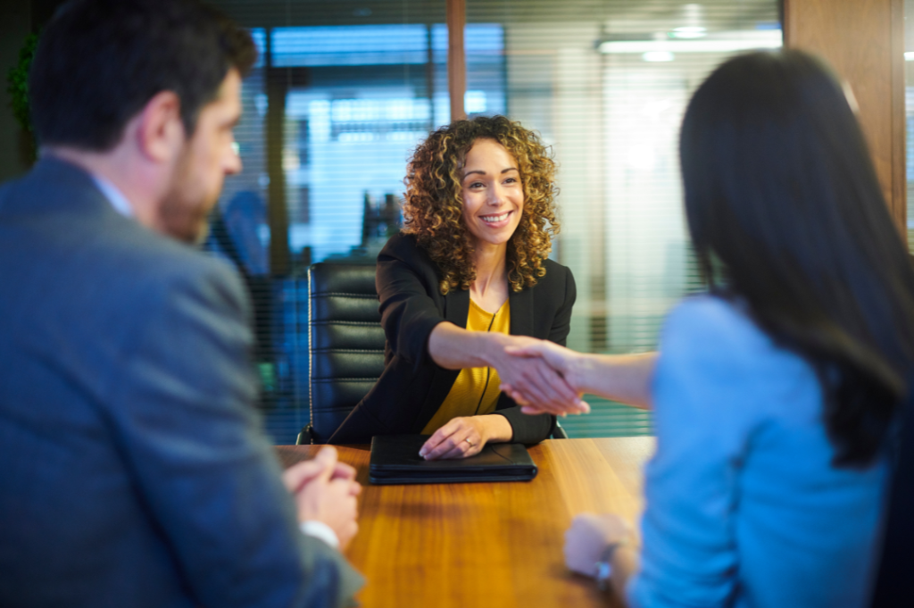 woman shaking hands with two people who interviewed her